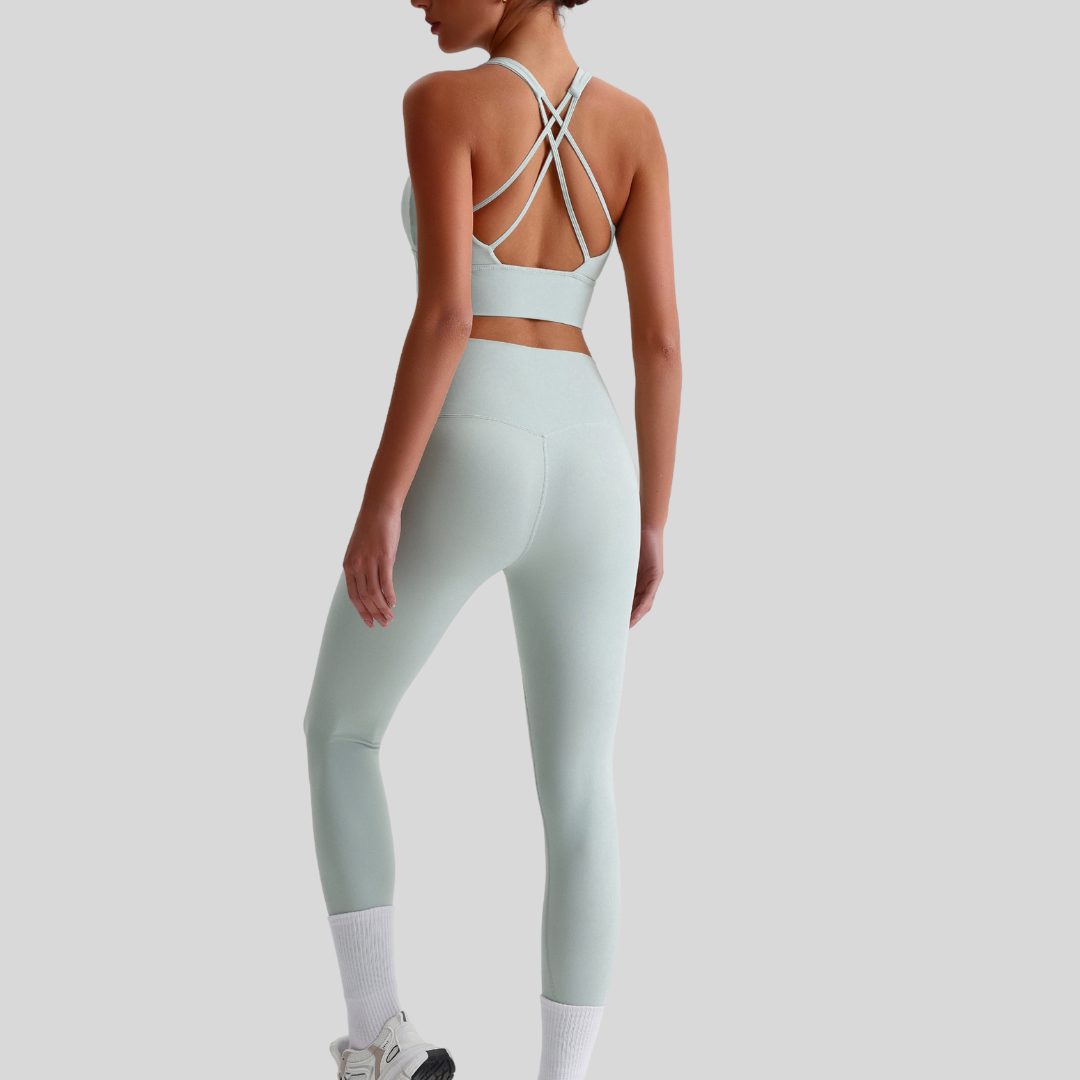 Back view of Kaos The Label Isla Set in Light Green, featuring crisscross sports bra straps and high-waisted leggings