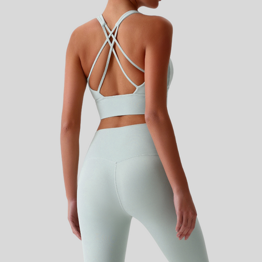 Back view of Kaos The Label Isla Set in Light Green, featuring crisscross sports bra straps and high-waisted leggings